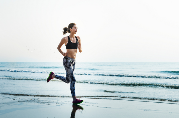kobieta w sportowym stroju biegnąca po plaży nnw odnowa