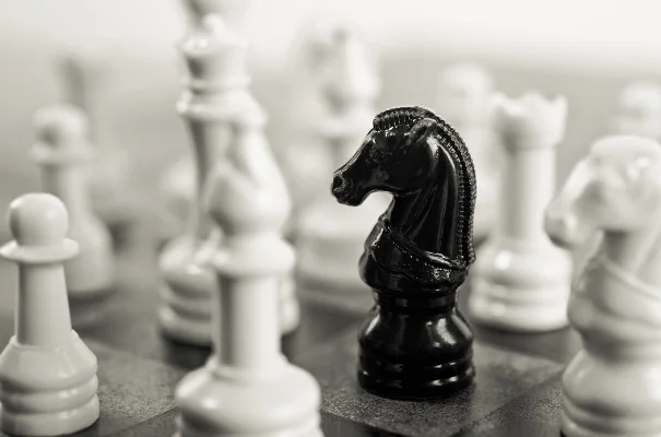 szachownica czarny goniec z towarzystwie białych figur